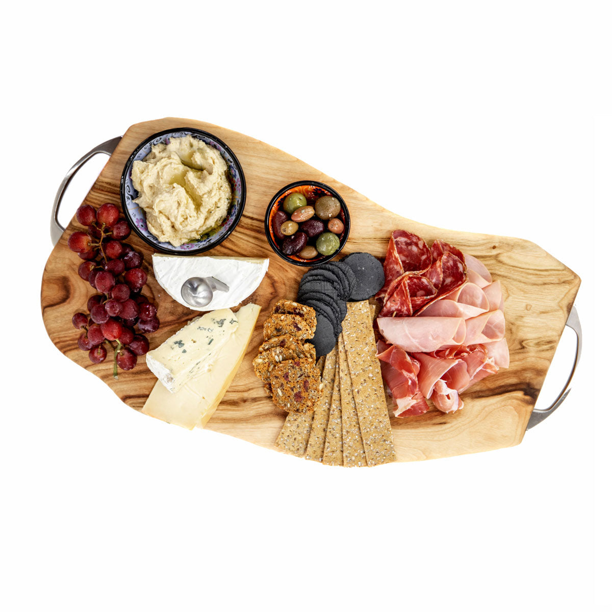 A large wood serving platter or wooden chopping board with stainless steel handles, made from camphor laurel timber designed by Nature's Boards, loaded up with cheese, crackers, olives, cured meat, hummus and grapes.