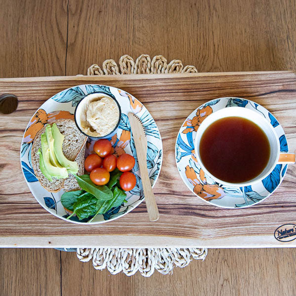 A small rectangular camphor laurel wood cutting board from Nature's Boards, being used as a serving board with tea, avo on toast with spinach, cherry tomatoes and hummus.