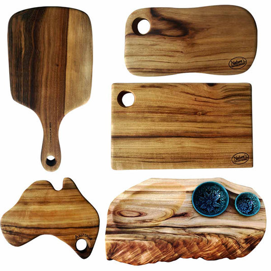 A combination of five small wooden boards: a charcuterie paddle board, a cheese platter with two handmade Turkish bowls, plus a freeform cutting board, a rectangular chopping board and an Australian-shaped food board all made with camphor laurel timber by Nature's Boards.